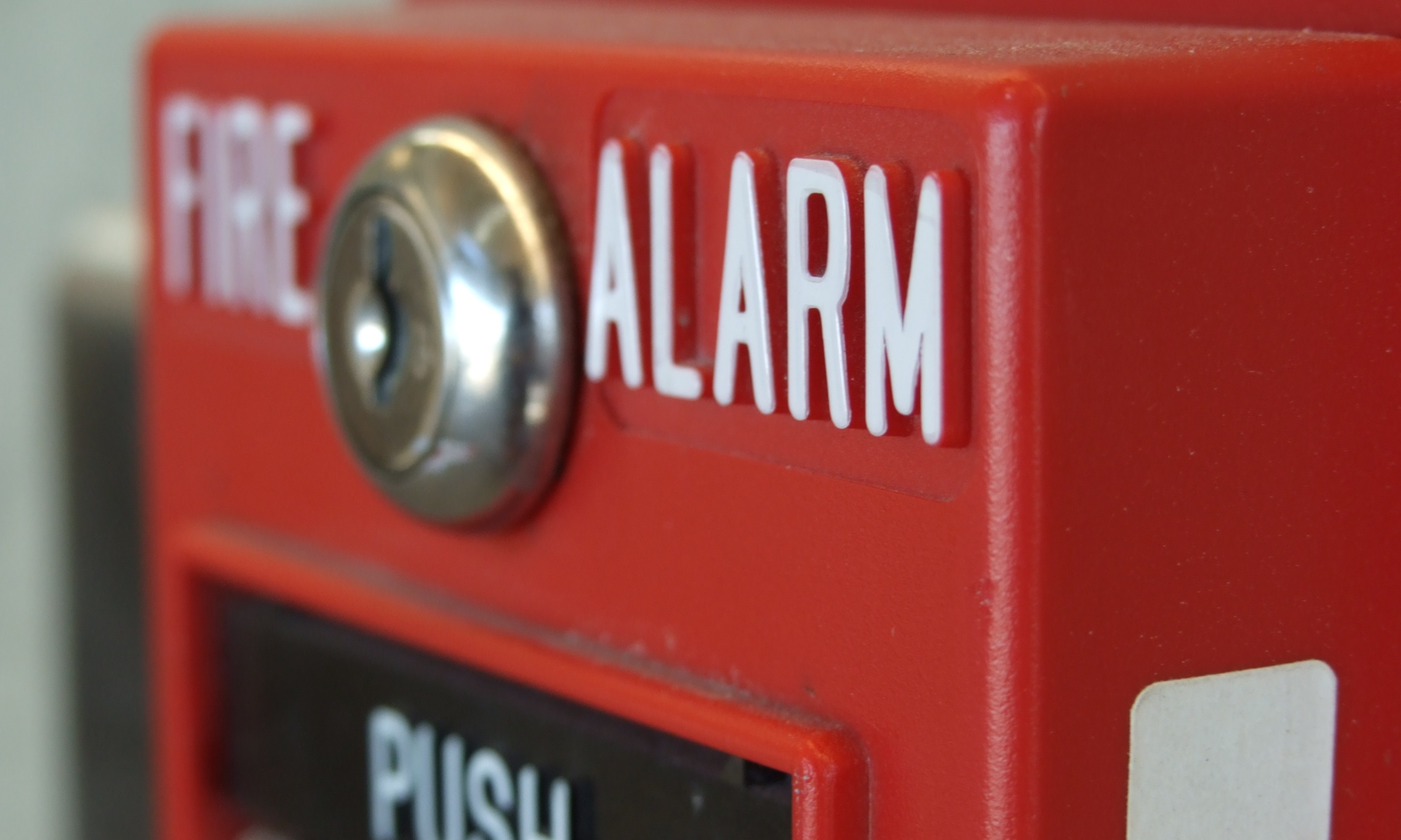 Detalhe de acionador manual vermelho de alarme de incêndio